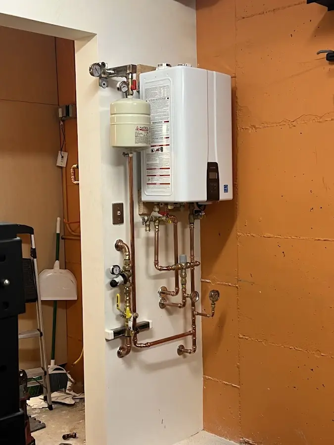Plumbing technician inspecting water heater connections in Nottawa